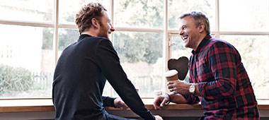 zwei Männer unterhalten sich in einem Café
