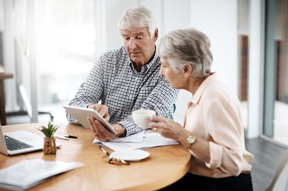Couple de seniors s'informant sur les tests auditifs en ligne