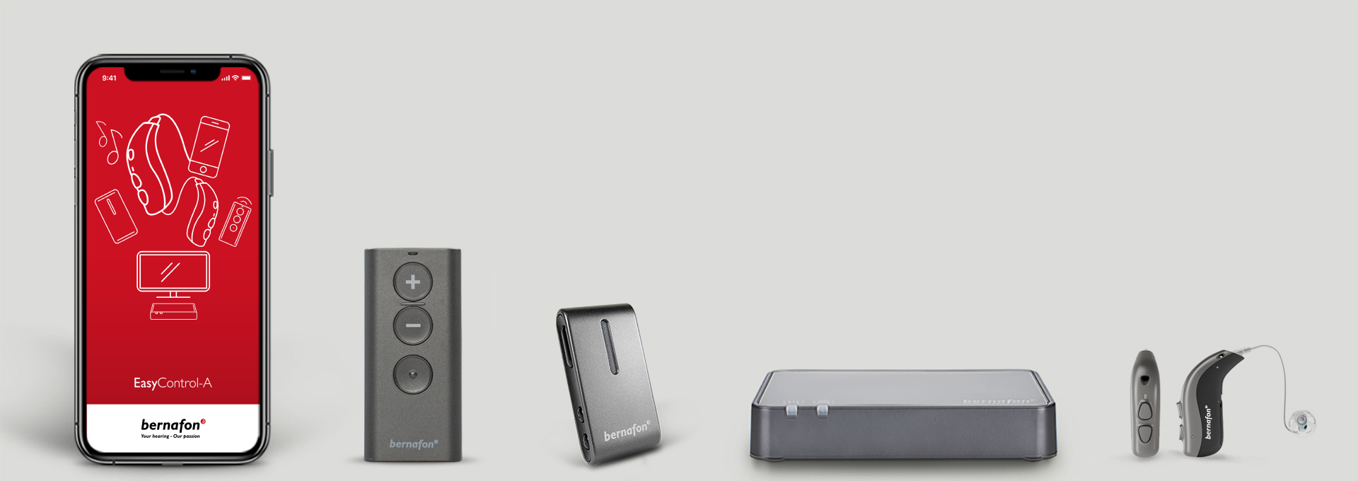 Bernafon accessoires op een rij, waaronder Bernafon app op een smartphone, TV adapter, afstandsbediening, hoortoestellen en Soundclip-A