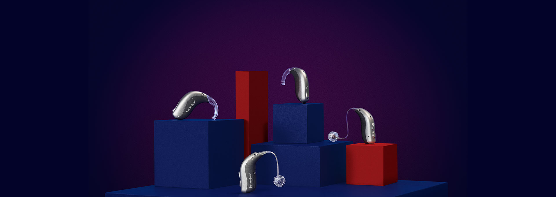 4 Bernafon Alpha hearing aids (miniBTE T R, miniRITE T R, miniBTE T, miniRITE T) on red and blue cubes with purple background