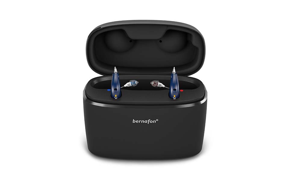 Chargeur Plus noir et portable avec couvercle ouvert pour deux aides auditives rechargeables Bernafon Alpha.
