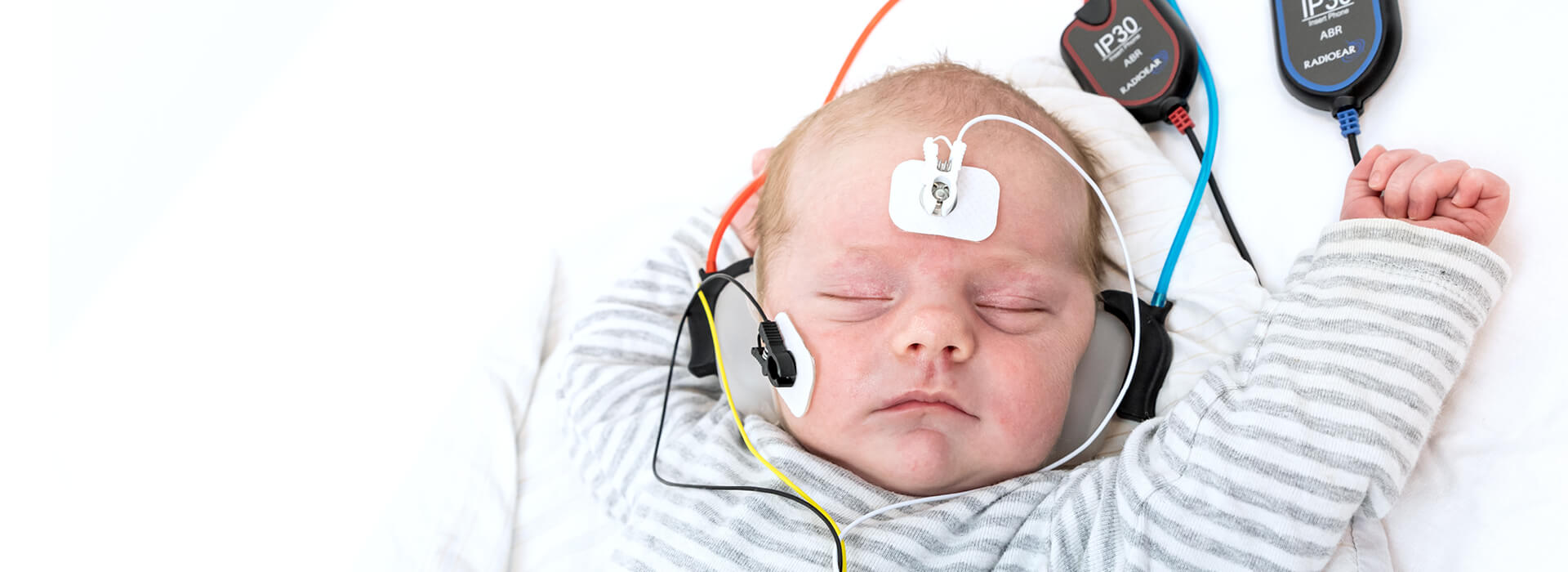 Sovende baby får foretaget høretest med OAE udstyr