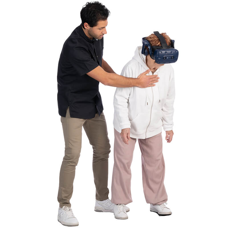 Un audiólogo ayuda a una mujer anciana con un ejercicio de rehabilitación de BalanceVR.