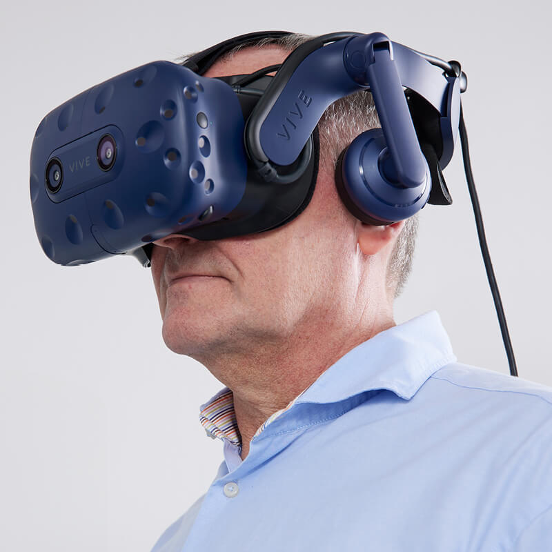 En äldre man i BalanceVR-mask.