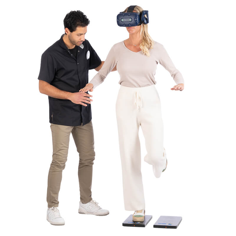 Ein Audiologe hilft einer Frau mit BalanceVR-Ausrüstung bei Gleichgewichtsübungen auf einem Bein auf den StaticVR-Kraftsensorplatten