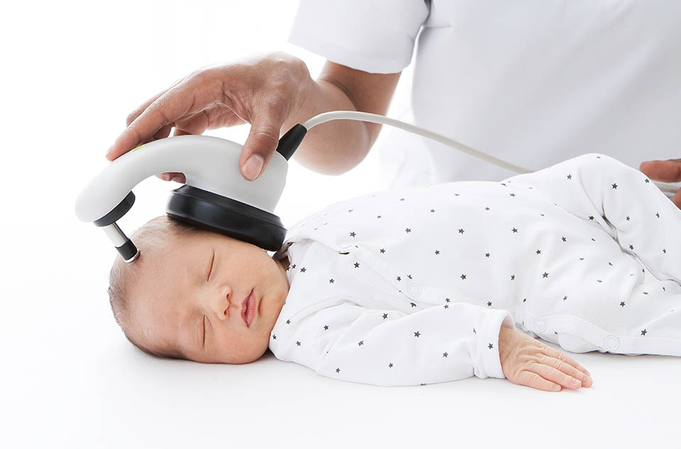 Close-up of sleeping baby while an ABR hearing test is conducted babyfriendly with a MAICO MB 11 BERAphone