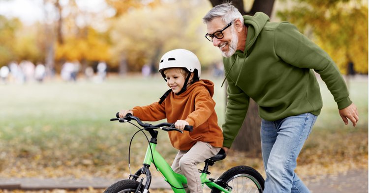 père avec son fils qui apprend à faire du vélo