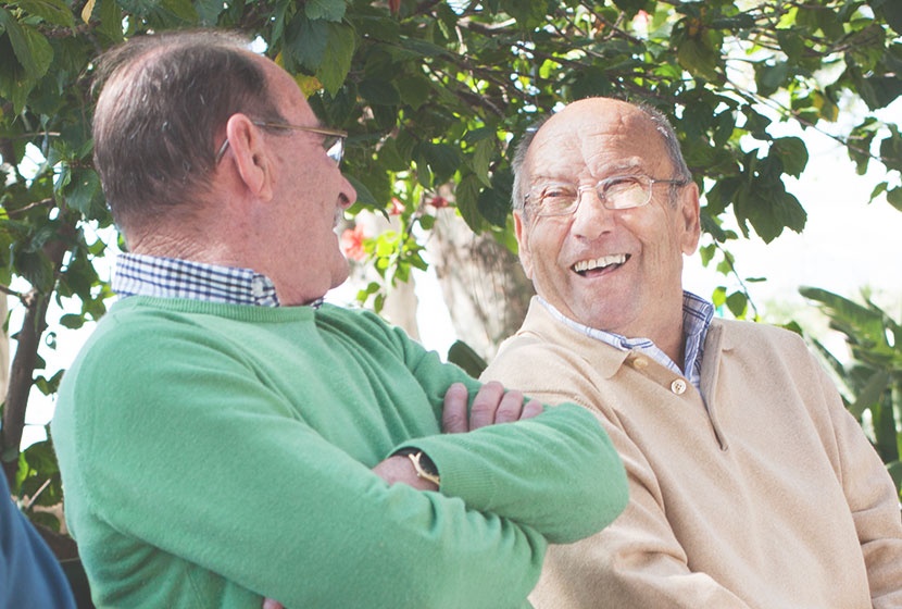 personnes âgées seniors parlant au soleil avec pull vert et beige