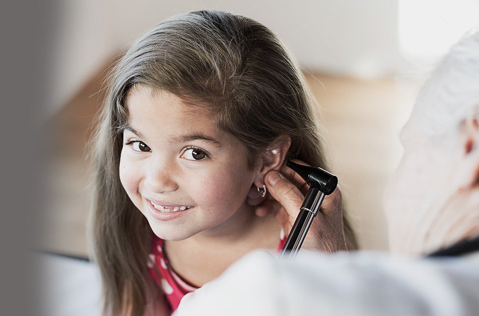 petit fille brune se faisant ausculter les oreilles par un médecin