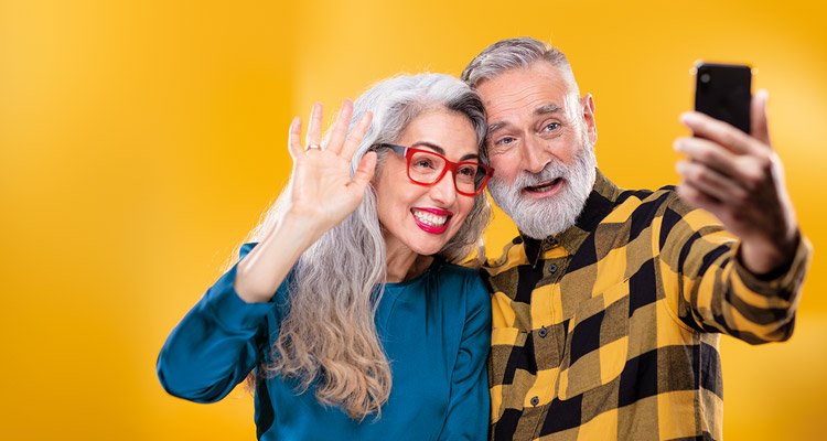 Middle-aged friends using a smartphone to connect to family and friends by making a video call