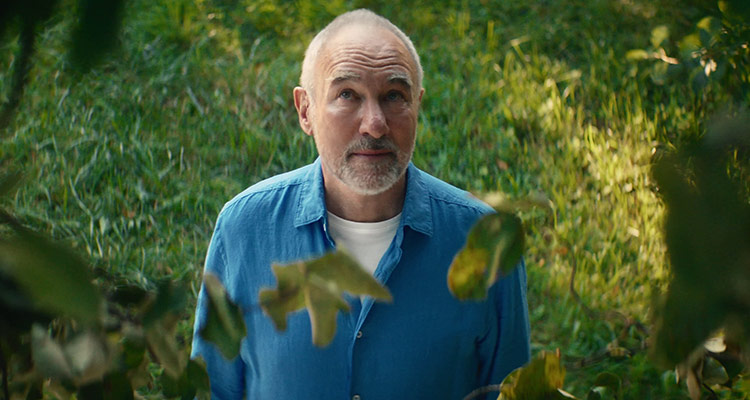 Middle-aged man in his garden wearing Philips HearLink hearing aids