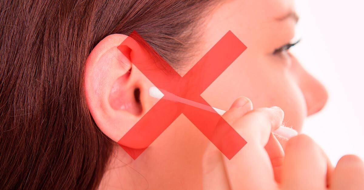 Une femme veut se laver les oreilles avec des bâtonnets d'oreille.