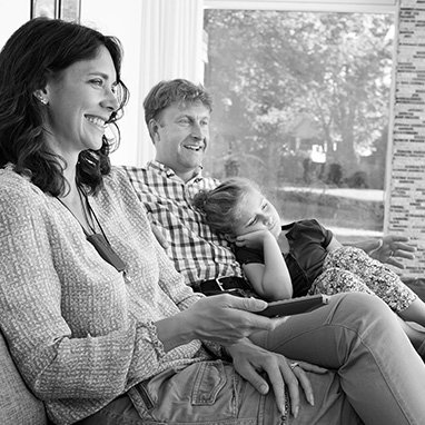 famille composée de la mère, le père et l'enfant, regardent la télévision dans leur salon en noir et blanc