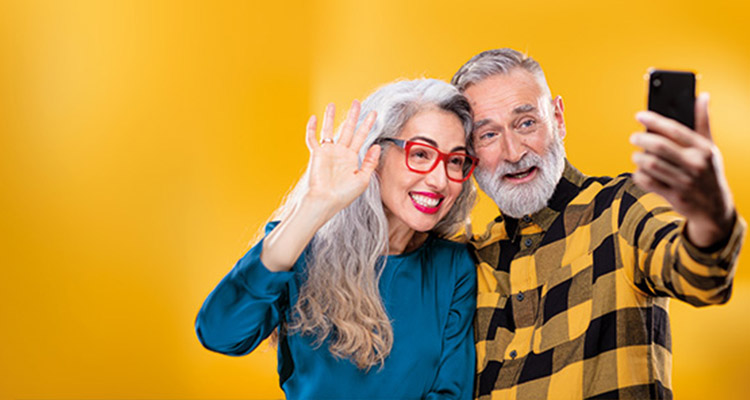 Middle-aged friends using a smartphone to connect to family and friends by making a video call.
