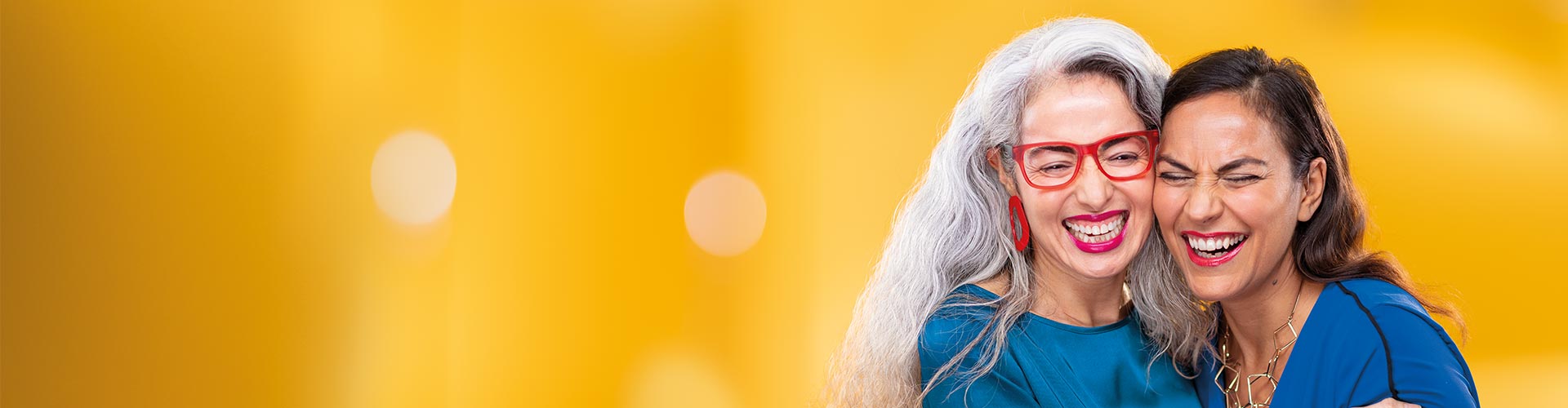 Twee vrouwen van middelbare leeftijd omhelzen elkaar. Eén van hen draagt Philips HearLink miniRITE T hoortoestellen.