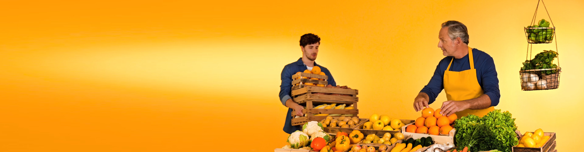 Philips HearLink şarj edilebilir işitme cihazı takan bir adam, sürdürülebilir tarım pazarında torununa portakal atarak onunla bağ kuruyor
